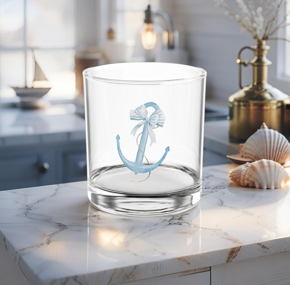 Cocktail glass with light blue anchor design on coastal table