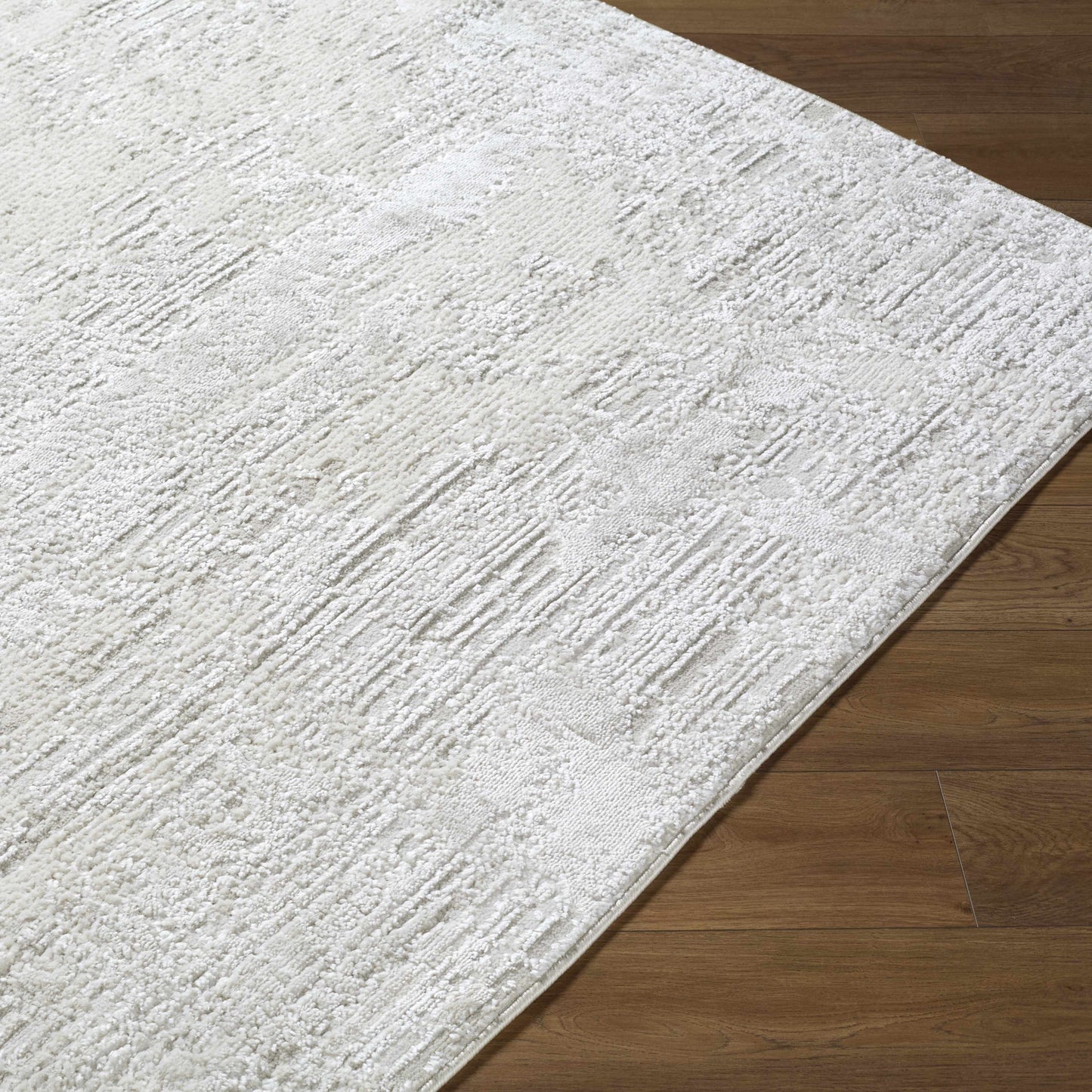A coastal farmhouse area rug in ivory, cream, and light gray tones styled in a bright beach house living room.