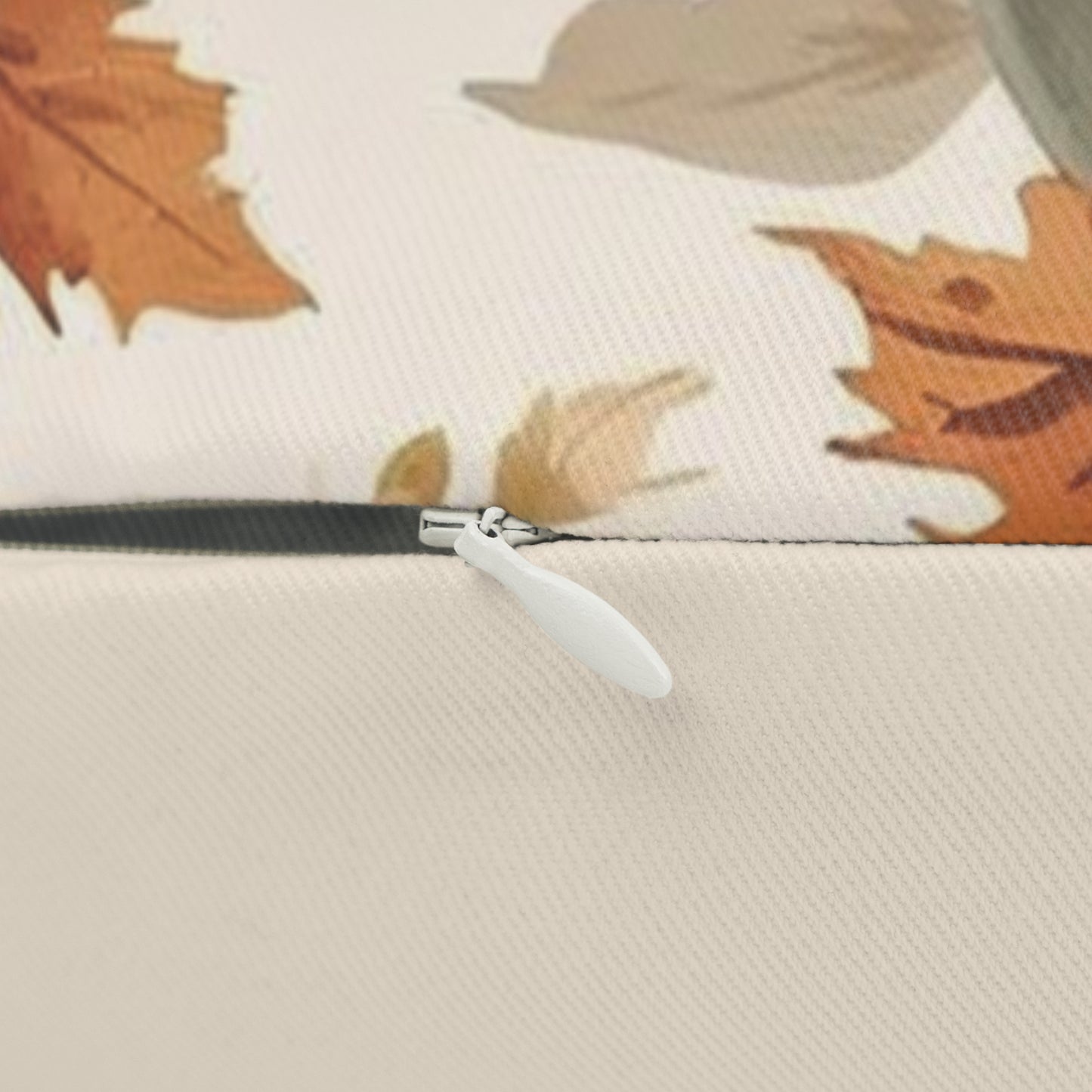 Close-up of a zipper on a fabric surface with autumn leaf pattern