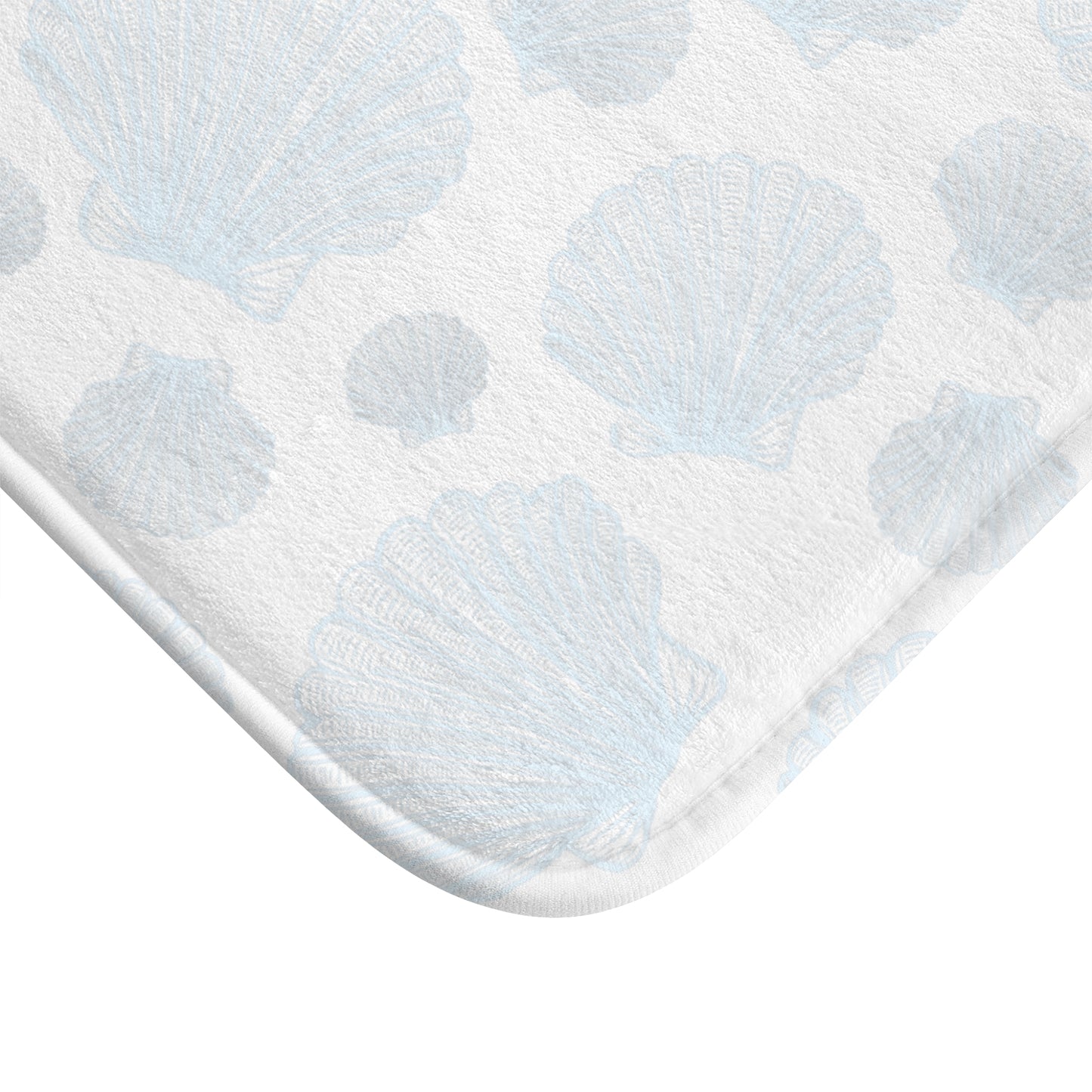 Turquoise bath mat with seashell prints, perfect for a serene and tropical bathroom feel