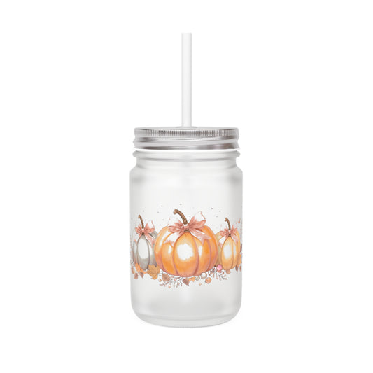 Mason jar tumbler with pumpkins and a straw on a white background