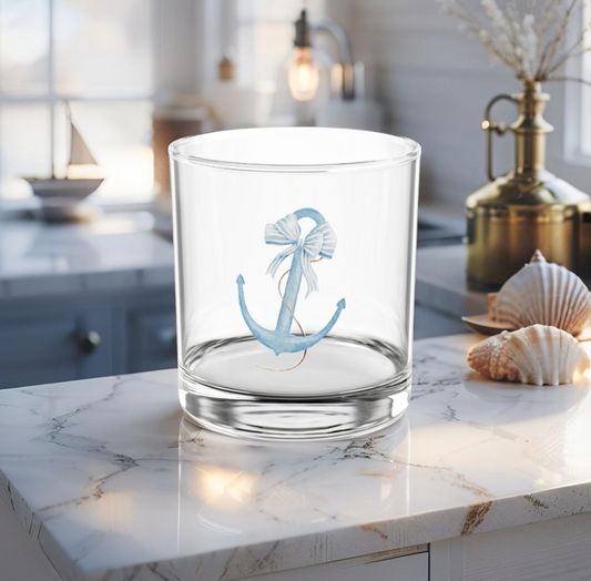 Cocktail glass with light blue anchor design on coastal table