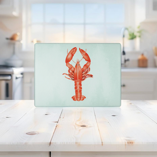 Red lobster glass cutting board for beach-themed kitchen countertops.