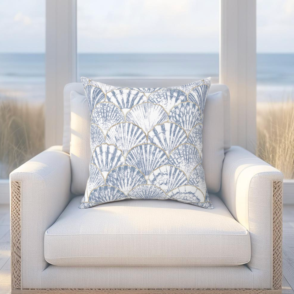Decorative seashell pillow in blue and white tones, ideal for ocean-inspired living rooms or bedrooms.