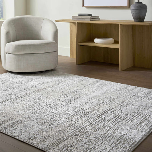 A coastal farmhouse area rug in ivory, cream, and light gray tones styled in a bright beach house living room.
