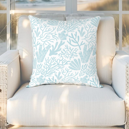 Decorative pillow featuring coral reef pattern in soft blue, ideal for beach house or coastal styling.
