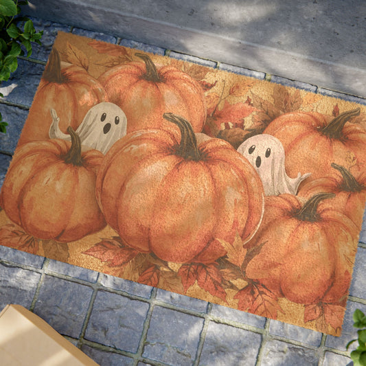 Decorative doormat with pumpkins and ghosts on a stone floor