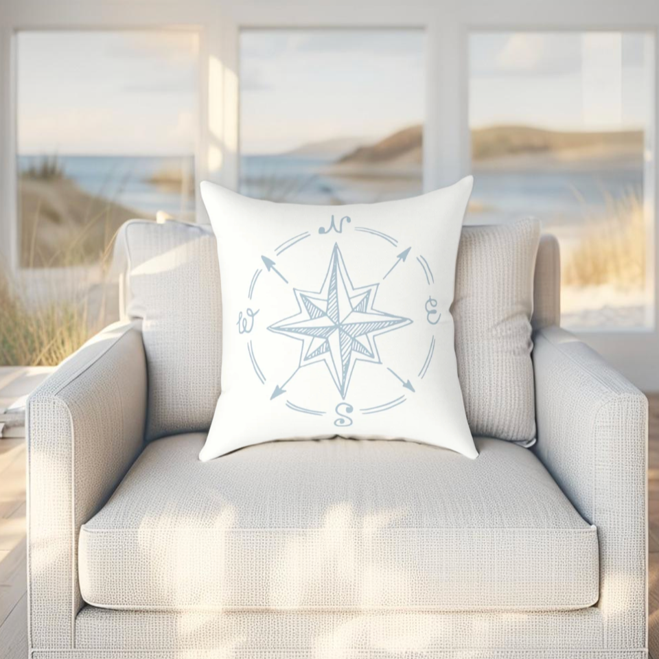 Light blue throw pillow with compass design, perfect for nautical and coastal-themed interiors.