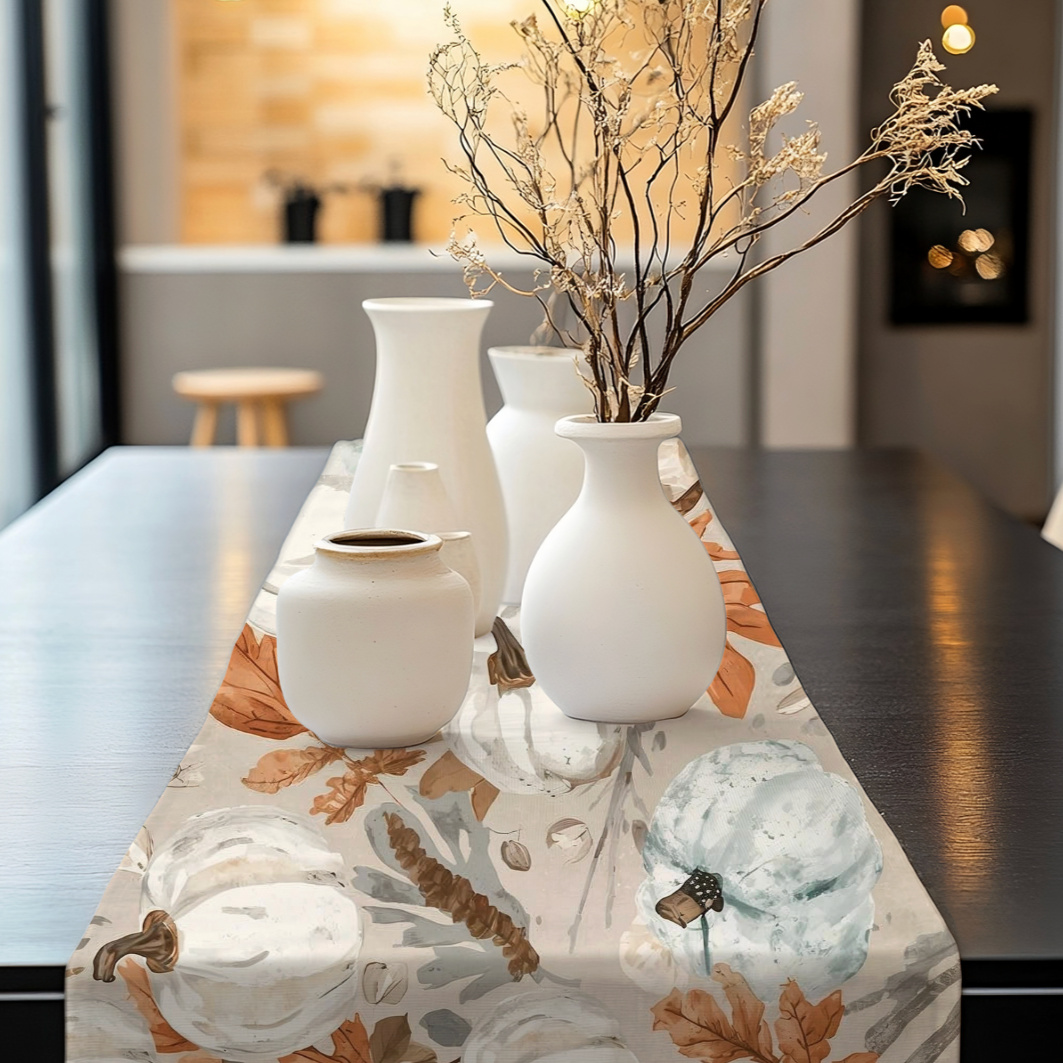 Fall coastal table runner with teal and white pumpkins, seashells, and autumn leaves on a luxury dining table.