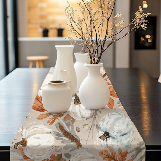 Fall coastal table runner with teal and white pumpkins, seashells, and autumn leaves on a luxury dining table.