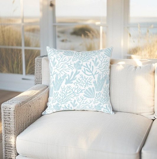 Light blue throw pillow with reef print design, perfect for coastal or ocean-inspired decor.