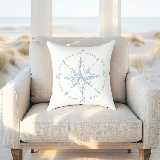 Nautical throw pillow with light blue compass print, great for seaside or ocean-inspired rooms.