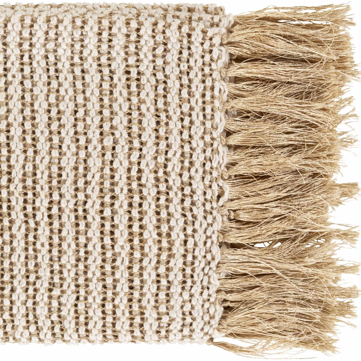 Tan knitted throw blanket with fringe draped over a white linen sofa in a coastal living room