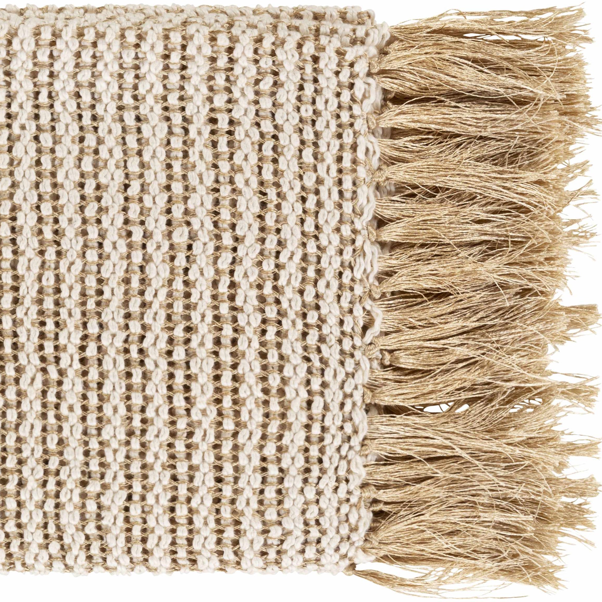 Tan knitted throw blanket with fringe draped over a white linen sofa in a coastal living room