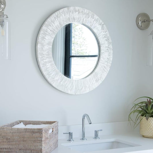 Round white seashell mirror styled in beach house entryway